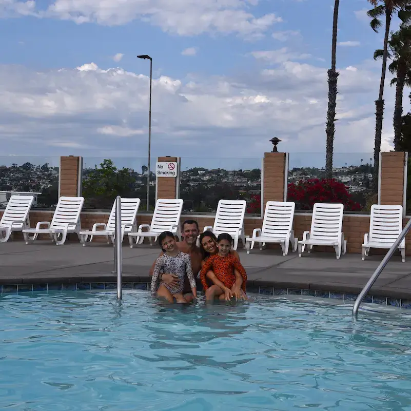 family posing at the pool