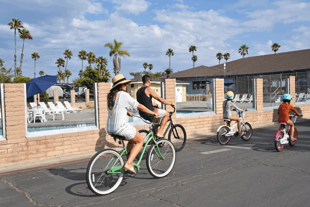 family bike riding past the pool